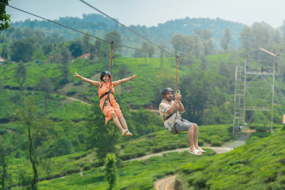 Tourist enjoying zipline wayanad activity flying over tea plantation resort wayanad