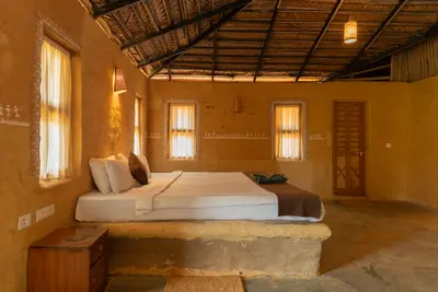 Rustic wooden double bed and earthy decor in the mud house wayanad rooms