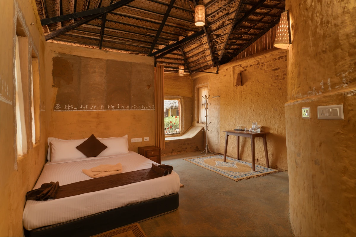 Rustic wooden double bed and earthy decor in the mud house wayanad rooms