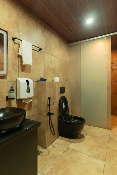 Modern shower area with a sleek black shower panel and textured tiles at boCHE 1000 Acre, one of the best resorts in Wayanad.