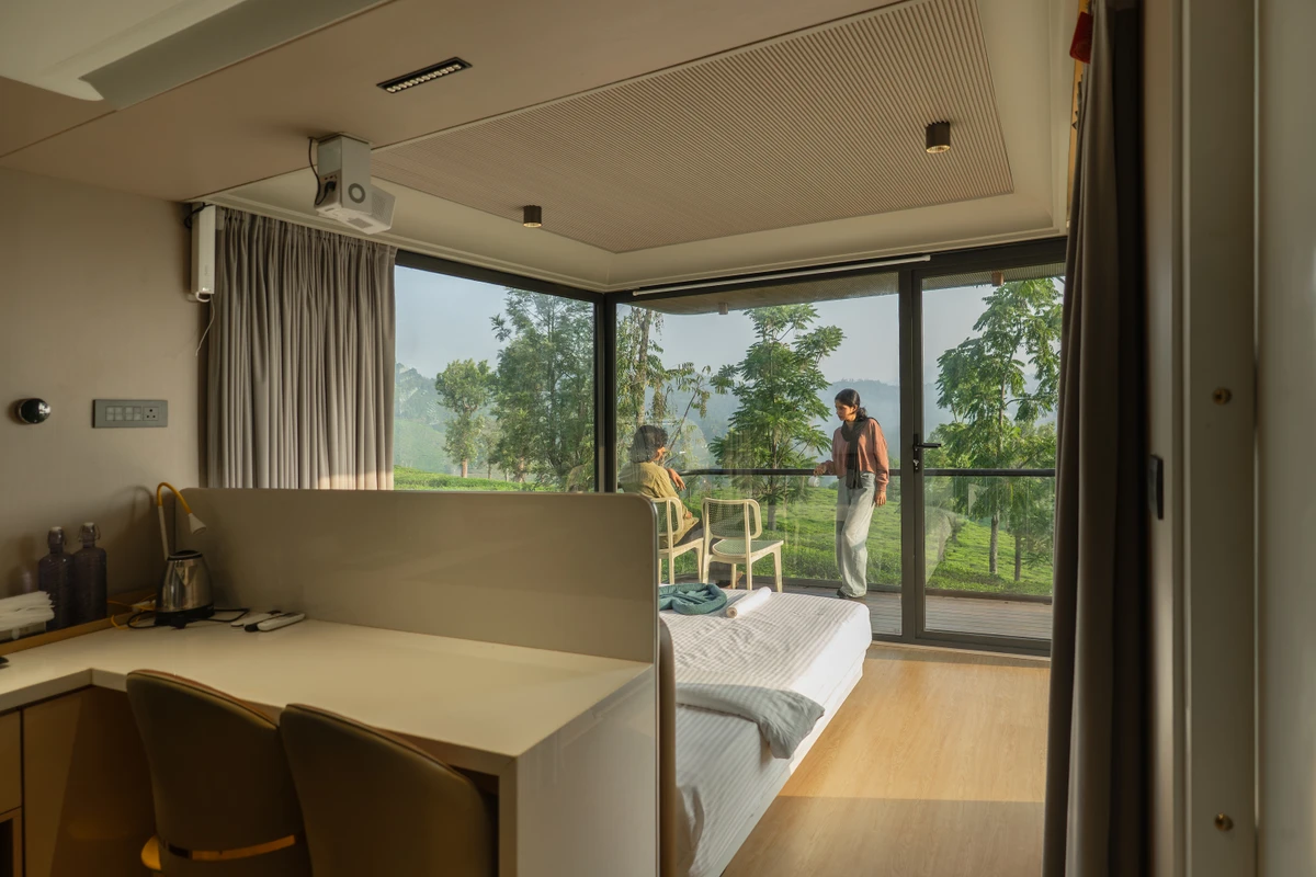 Luxury double bed with floor-to-ceiling plantation views inside xpod boche 1000 acre resort wayanad